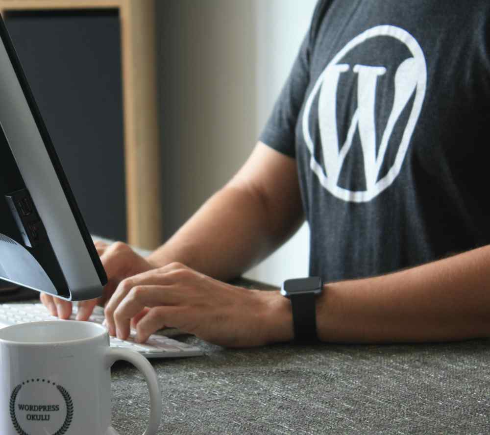Mann mit Wordpress T-Shirt am Computer